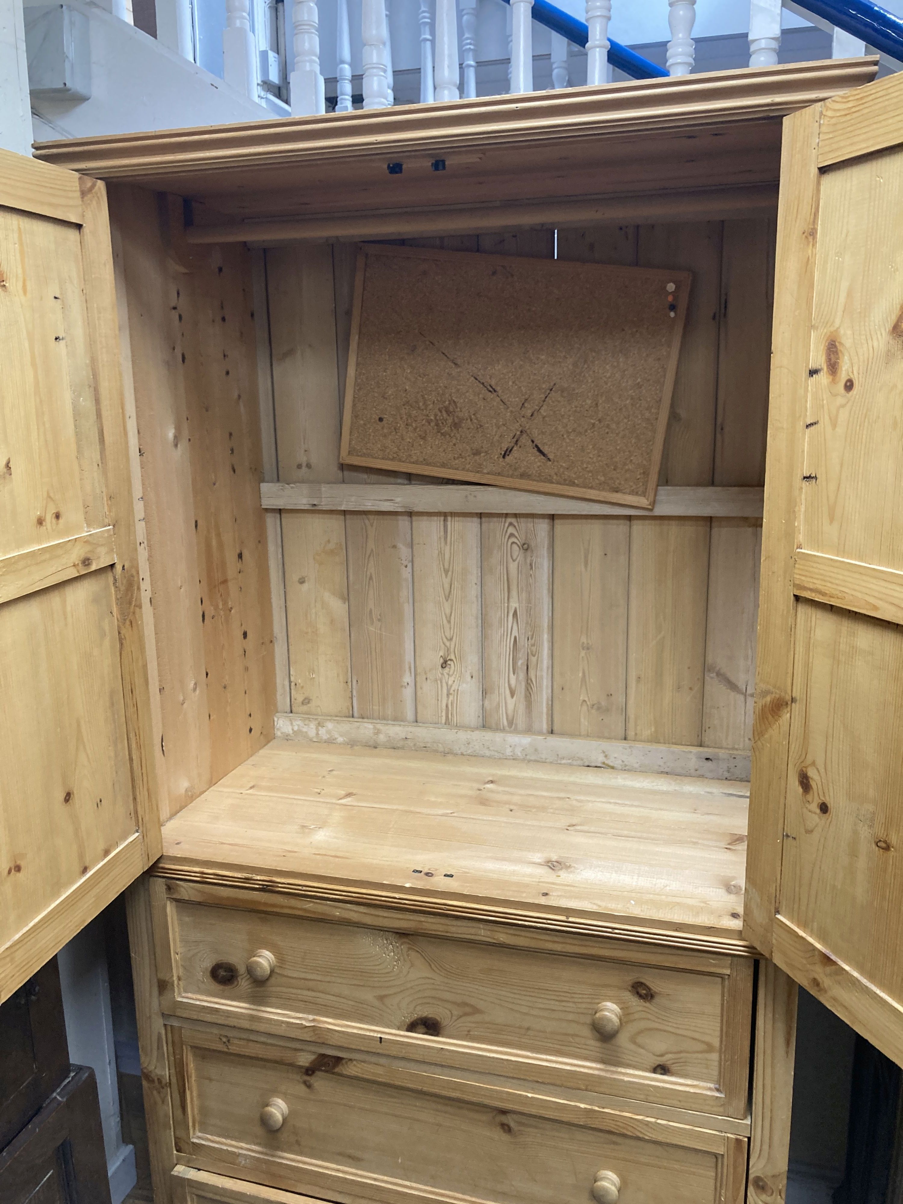 A contemporary pale pine press cupboard with twin panelled cupboard doors over a base fitted with three long drawers, height 199cm, width 105cm depth 57cm